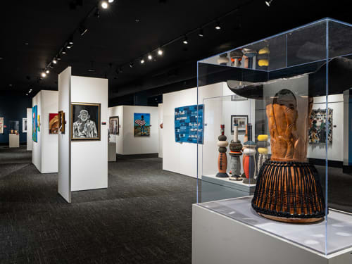 Gallery of artwork with inverted decorated drum in case in foreground