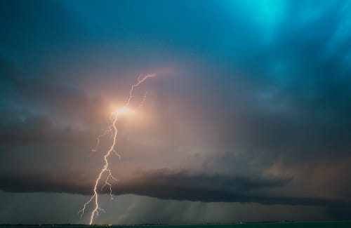 A lightning ground strike from a swirling blue sky