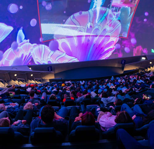 Large multicolored movie screen with seated audience