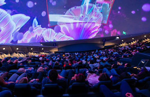 Large multicolored movie screen with seated audience