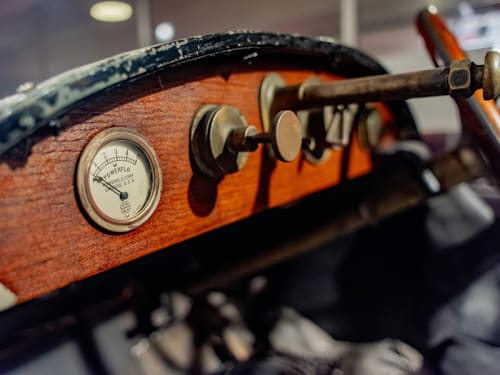 Wooden dashboard of an antique automobile with metal gauges