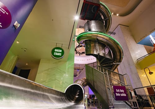 Curling multi-story steel slide with opening in foreground