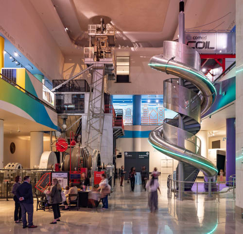 Powering the Future exhibit with people below tall spiral slide, near Coal Mine