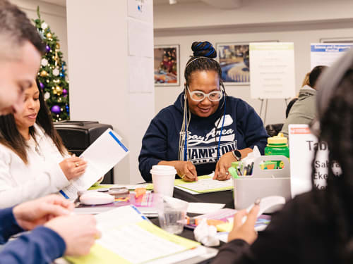 Teacher at conference table applying labels to a worksheet
